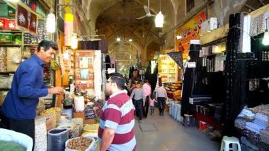 Şiraz, Iran - 14 Ekim 2017: Baharat deposu müşteri fındık, piyasada uzun tarihi sokak ile arka planda, 14 Ekim'de Shiraz içinde görülür Vakil ın Bazaarı muamele etmek içinde satıcı.
