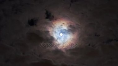 Hızlı bulutlar gece gökyüzünde dolunay ile çalışan, ışık Ayla ve renkli ay corona (optik fenomen ile çevrili).