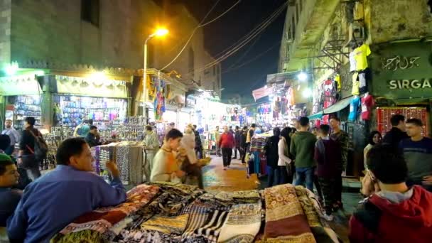 カイロ エジプト 2017 複数の照らされた店と 日カイロで 前景に伝統的なスカーフの失速にハン ハリーリ市場の混雑した夜の通り — ストック動画