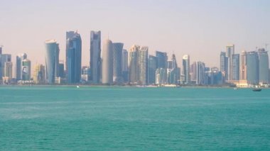 Doha, Katar - 13 Şubat 2018: İkonik manzarası ile Basra Körfezi zümrüt suların üzerinde ön plan, West Bay sahil üzerinde Şubat 13 Doha yükselen Doha futuristik gökdelen, sıra ile.