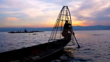 Birman balıkçı, hileler net, onun Kano, Inle Gölü, Myanmar kenarında oturan ile gösterilen karanlık siluet.