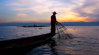 Inle Gölü - günbatımı Balık tutma sanatı Birmanya balıkçı kürek çekmeye ve onun Kano, Myanmar kenarında duran konik net ile balıkçılık bir bacak hünerlerini gösterir.. 