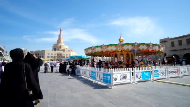 卡塔尔 2018年2月13日 Waqif 旁边的游乐园拥挤的街道上 在2月13日在多哈举行的 Fanar 清真寺老式旋转木马和螺旋尖塔的看法 — 图库视频影像