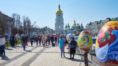 KYIV, UKRAINE - APRIL 14, 2018: Walk along the Easter eggs on Vladimirska street to Sofiyska square during Easter Festival, bell tower of St Sofia Cathedral rises on background, on April 14 in Kyiv.