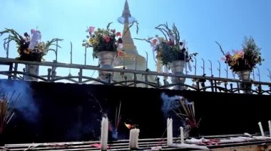 Sunak Budist Dini teklifleri - çiçek, mum ve tütsü ile sopa, altın Kyaiktiyo Pagoda üstündeki dev altın granit kayanın üzerinde arka planda, Kyite Htee Yoe Mount, Myanmar görülür.