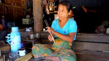 Chaung Tha, Myanmar - 1 Mart 2018: Birmanya kadın 1 Mart Chaung Tha içinde farklı şeyler - konik şapkalar, tabaklar, sepetler, duvar ve çatı panelleri, dokuma için bambu dar şeritler yapar.