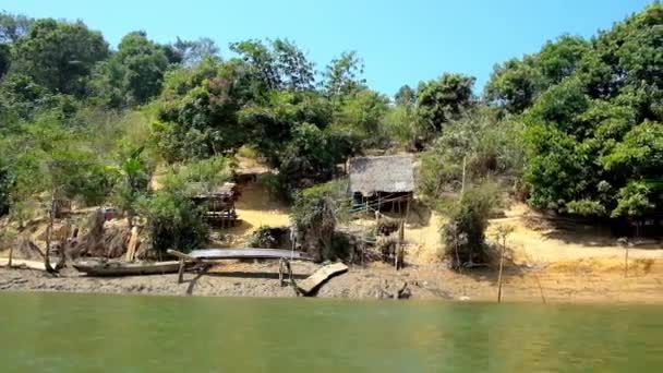 本山義川のほとりに小さな漁村の集落を探索 ぼろぼろの木造住宅がミャンマー ガーペー 丘の斜面の木の中で隠されています — ストック動画