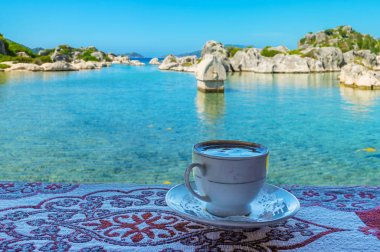 Cup of Turkish coffee on coast of Kekova Bay, Kalekoy, Turkey clipart