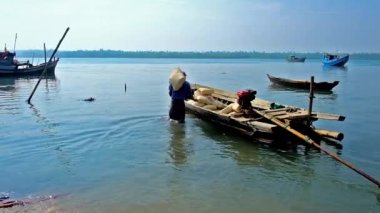Chaung Tha, Myanmar - 1 Mart 2018: İşçiler İnşaat malzemeleri köyün limanda 1 Mart Chaung Tha içinde çanta ile tekne yük.