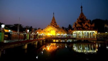 Ortaçağ Zayer Yar Aung Myay gölet, Yangon, Myanmar yansıtan Manastırı ışıklı stupa ve Köşk, akşam görünümünü.