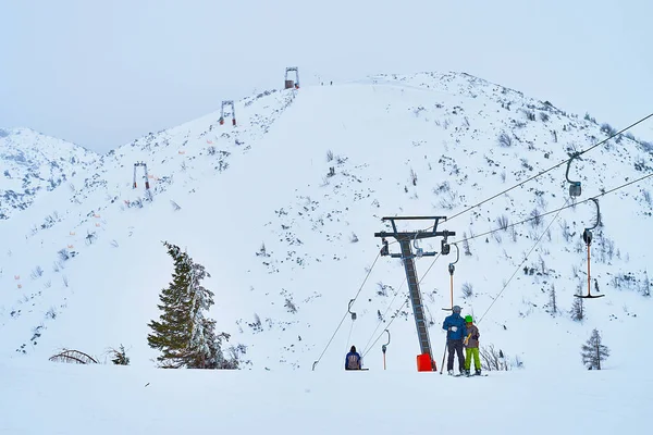 People on button ski lift on Feuerkogel mountain plateau, Salzka