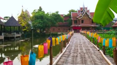 Wat Chetlin (Jedlin) tapınağı, Chiang Mai, Tayland 'daki bambu köprüsünde renkli fenerlerle yürüyün.