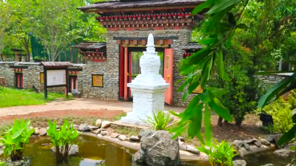 2019年5月7日 泰国清迈 位于拉贾普吕克皇家公园不丹花园池塘边的白色绳衣 5月7日 位于清迈 背景为彩色木雕的华丽大门 — 图库视频影像