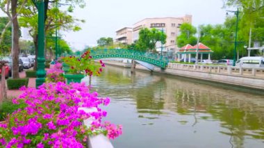 Khlong Phadung Krung Kanalı 'nın üzerindeki yeşil köprü taş balyaları, ağaçlar, çiçek açan bougainvillea çalıları, klasik sokak lambaları, Dusit, Bangkok, Tayland