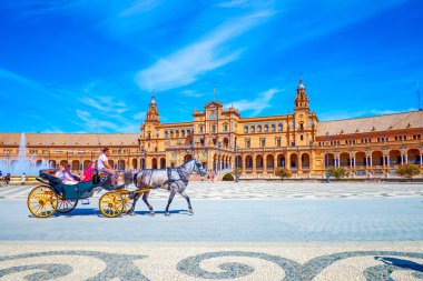 The tourists in the carriage on Plaza de Espana in Seville