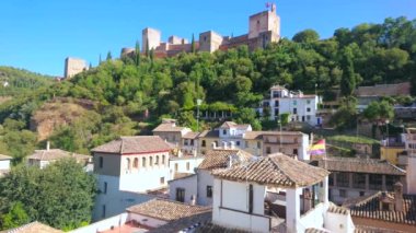 Alhambra duvarları ve kuleleri olan eski Granada şehri, İspanya 'nın yemyeşil tepelerinden yükseliyor.