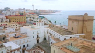 Taştan kulesi, Santa Cruz Cemaati kilisesi, yaşam yapıları ve Atlantik Okyanusu kıyısı, Costa de la Luz, İspanya 'nın ortaçağ kıyı bölgesi manzarası.