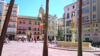 Malaga, İspanya - 26 Eylül 2019: Ceneviz Çeşmesi (Fuente de Genova) ile Anayasa Meydanı (Pedestrian Plaza de la Constitucion) ve palmiye gövdelerinin arkasındaki eski yapılar, 26 Eylül 'de Malaga' da