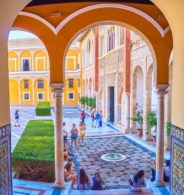 Gençler İspanya, Seville 'deki Alcazar Sarayı' nın avlusunda oturuyorlar.