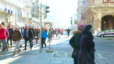 VIENNA, AUSTRIA - FEBRUARY 19, 2019: The crowd of people, walking the crosswalk in Karntner Strasse, lined with historic edifices and Opera House, on February 19 in Vienna