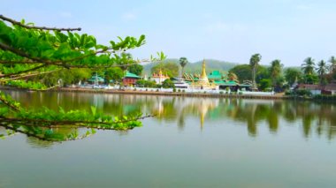 Nong Kham gölünün ayna yüzeyi tarihi Wat Chong Kham ve Wat Chong Klang tapınaklarını yansıtır, yemyeşil, Mae Hong Son, Tayland