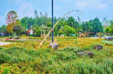 Chiang Mai, Tayland - 7 Mayıs 2019: Rajapruek parkının çiçek bahçesi balıkçılık kurulumuyla süslenmiştir - tahta balık yeşillikler arasında yüzer ve bambu çubuğu çiçeklerin üzerine eğilir, 7 Mayıs 'ta Chiang Mai' de