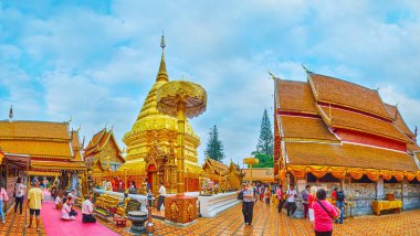 CHIANG MAI, THAILAND - MAY 7, 2019: Panorama of Wat Phra That Doi Suthep temple complex with wihans (shrines), topped with tile pyathat roofs, tall chatra umbrella and chedi, covered with gilt, on May 7 in Chiang Mai clipart