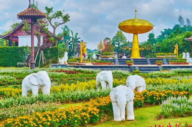Chiang Mai, Tayland - 7 Mayıs 2019: 7 Mayıs 'ta Chiang Mai' de Rajapruek parkının simgesi olan altın duş ağacının önündeki beyaz filler heykel grubu