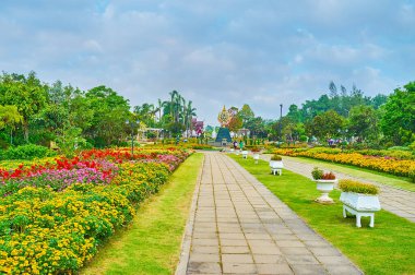Chiang Mai, Tayland - 7 Mayıs 2019: Rajapruek parkında çiçek tarlaları, saksılarda bitkiler ve uzaktaki Kraliyet Amblemi manzarası ile birlikte 7 Mayıs 'ta Chiang Mai' de yürüyüş