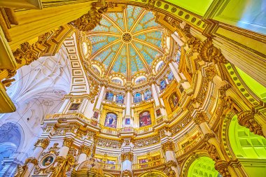 GRANADA, SPAIN - SEPTEMBER 25, 2019: The inner cupola of  Main Chapel (Capilla Major) of Cathedral with stars on blue sky, plasterwork, gilt garlands and stained-glass windows, on September 25 in Granada