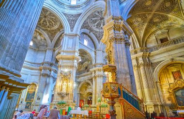 GRANADA, SPAIN - SEPTEMBER 27, 2019: Explore historic Baroque prayer hall of Sagrario (Sacred Heart) church with relief stone columns, ornate domes, carved wooden pulpit and rich decors, on September 27 in Granada