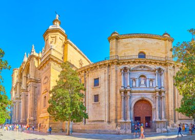 GRANADA, SPAIN - SEPTEMBER 27, 2019: Panorama of Plaza de Alonso Cano square with medieval Sagrario church and huge building of Cathedral with tall bell towers and great portals, on September 27 in Granada
