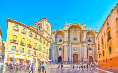 GRANADA, SPAIN - SEPTEMBER 25, 2019: Panorama of the facade of Cathedral, shaped as Triumphal arch and decorated with stone columns, sculptures and garlands, on September 25 in Granada