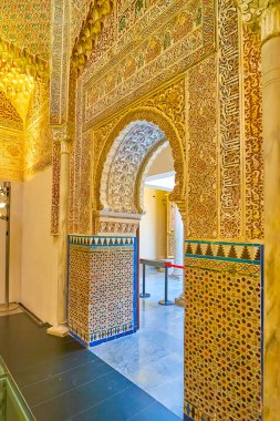 GRANADA, SPAIN - SEPTEMBER 27, 2019: Mudejar horseshoe door in  mosque of Palacio de la Madraza (Madrasah), richly decorated with tilling, fine patterns, arabesques, sebka, on September 27 in Granada