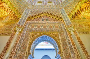 GRANADA, SPAIN - SEPTEMBER 27, 2019: Fine sebka decor in historic mosque of Palacio de la Madraza (Madrasah) with horseshoe door, mocarabe details, calligraphy, arabesques, on September 27 in Granada clipart