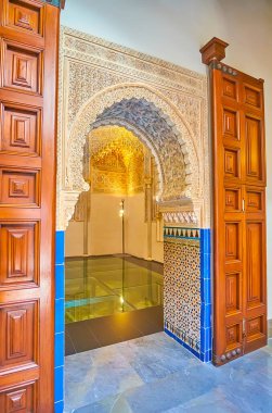 GRANADA, SPAIN - SEPTEMBER 27, 2019: Traditional horseshoe doorway to the Mosque of Palacio de la Madraza (Madrasah), decorated with sebka and fine tilling, on September 27 in Granada