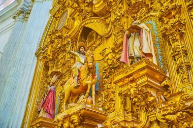 GRANADA, SPAIN - SEPTEMBER 25, 2019: The close-up details of Triunfo de Santiago Chapel in Granada Cathedral with ornate gilt plasterwork around the sculptures of saints and equestrian statue, on September 25 in Granada clipart