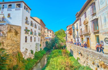 GRANADA, SPAIN - SEPTEMBER 25, 2019: Crowded Carrera del Darro street of Albaicin district, located in gorge and lined by Darro river, historical edifices and mansions, on September 25 in Granada