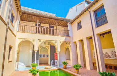 GRANADA, SPAIN - SEPTEMBER 25, 2019: The beautiful court of medieval Arabic Casa de Zafra with a pond, arcade, carved arabesques and wooden terrace, on September 25 in Granada