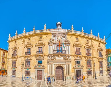 GRANADA, SPAIN - SEPTEMBER 25, 2019: The facade of High Court of Justice edifice, decorated with molding, carved stone entrance portal and clock tower, located in Plaza Nueva square, on September 25 in Granada
