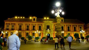 SEVILLE, SPAIN - 1 Ekim 2019: Plaza Virgen de los Reyes Meydanı 'ndaki tarihi Başpiskopos Sarayı manzaralı sokak lambası çeşmesi ile 1 Ekim akşamı Seville' de