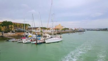 EL PUERTO, SPAIN - 21 Eylül 2019: 21 Eylül 'de El Puerto' daki tersanelere demirlemiş yatlar ve tekneler manzaralı Guadalete nehir kenti boyunca yapılan gezi