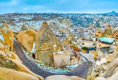 Dar virajlı yol, Goreme, Kapadokya, Türkiye 'deki kayalıklar ve küçük evler arasında uzanıyor