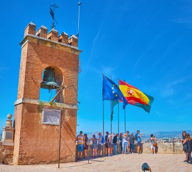 GRANADA, İspanya - SEPTEMBER 25 Eylül 2019: 25 Eylül 'de Granada' da, tuğla çan kulesi, bronz çan ve bayraklarla Alcazaba Kalesi 'nin (Torre de la Vale) izleme platformu