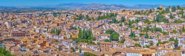 Alhambra duvarlarından eski Granada 'nın panoramik manzarasının tadını çıkarın, tarihi mahallelere, yoğun binalara ve arka plandaki Sierra Nevada dağlarına bakın, İspanya