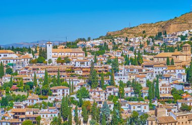 Granada 'nın tepe manzarası, Albaicin bölgesinin eski evleri ve İspanya' nın yüksek beyaz çan kulesiyle St. Nicholas kilisesi.