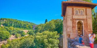 GRANADA, SPAIN - 25 Eylül 2019: 25 Eylül 'de Granada' da, arka planda Alhambra Generalife bahçelerinin yemyeşil yeşilliği bulunan ortaçağ Partal Şapeli Panoraması (oratoryo)