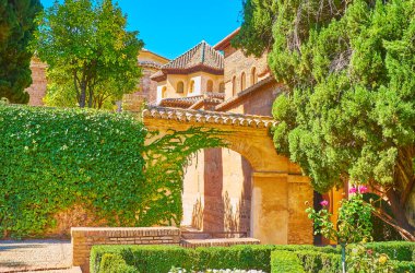 Nasrid Sarayı 'nın eski kemerli geçidi. Etrafı süslü Partal Bahçesi, Alhambra, Granada, İspanya' nın yemyeşil bahçeleriyle çevrili.