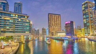 DUBAI, BAE - 2 Mart 2020: Dubai Marina üzerindeki alacakaranlık, fütüristik cam gökdelenler, yüzen botlar ve parlak aydınlatma ile, 2 Mart 'ta Dubai' de