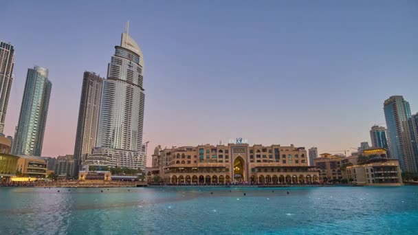 DUBAI, UAE - MARCH 3, 2020: The sunset over the dancing Dubai Fountain, located on Burj Khalifa lake, with  aview on Souk Al Bahar market and futuristic skyscrapers, on March 3 in Dubai